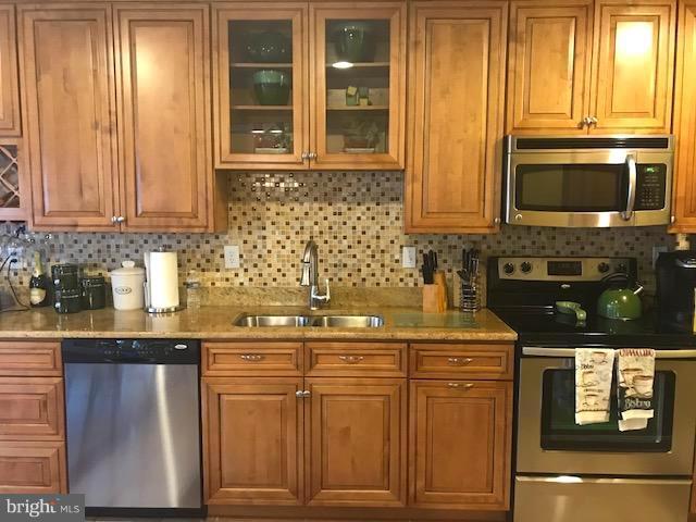 9202 Oregold Court Laurel, MD 20708 - Photo 8 of 29 a kitchen with stainless steel appliances granite countertop a stove microwave and cabinets