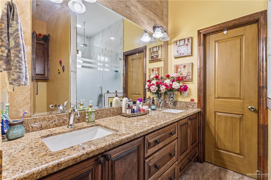 717 West 27th Street Mission, TX 78574 - Photo 12 of 18 a bathroom with a granite countertop sink and a mirror