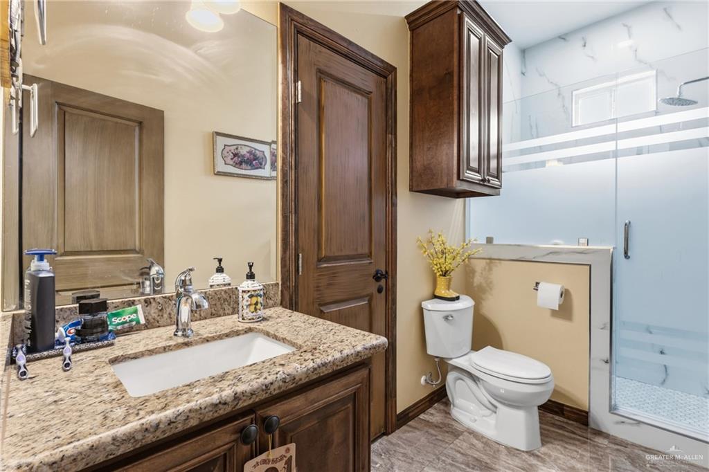 717 West 27th Street Mission, TX 78574 - Photo 13 of 18 a bathroom with a granite countertop toilet sink and mirror
