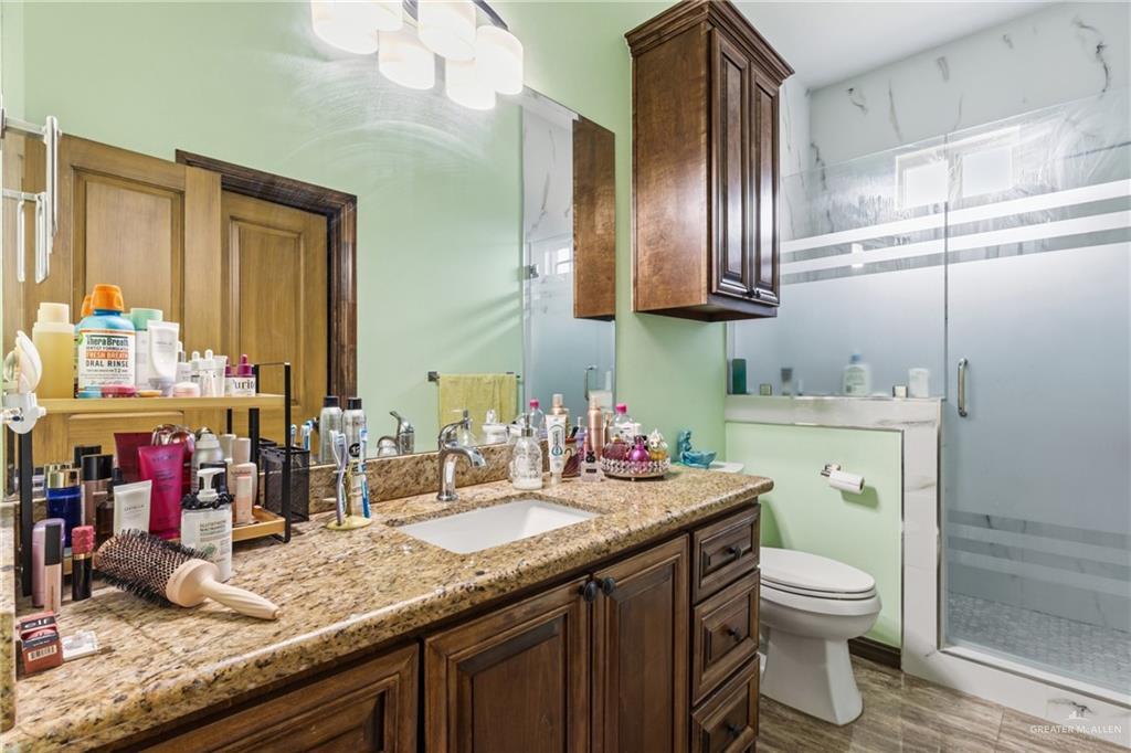 717 West 27th Street Mission, TX 78574 - Photo 14 of 18 a bathroom with a granite countertop toilet sink and mirror