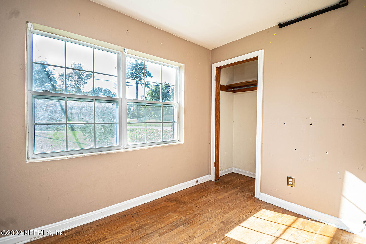 2445 Community Road Jacksonville, FL 32207 - Photo 23 of 42 an empty room with wooden floor and windows