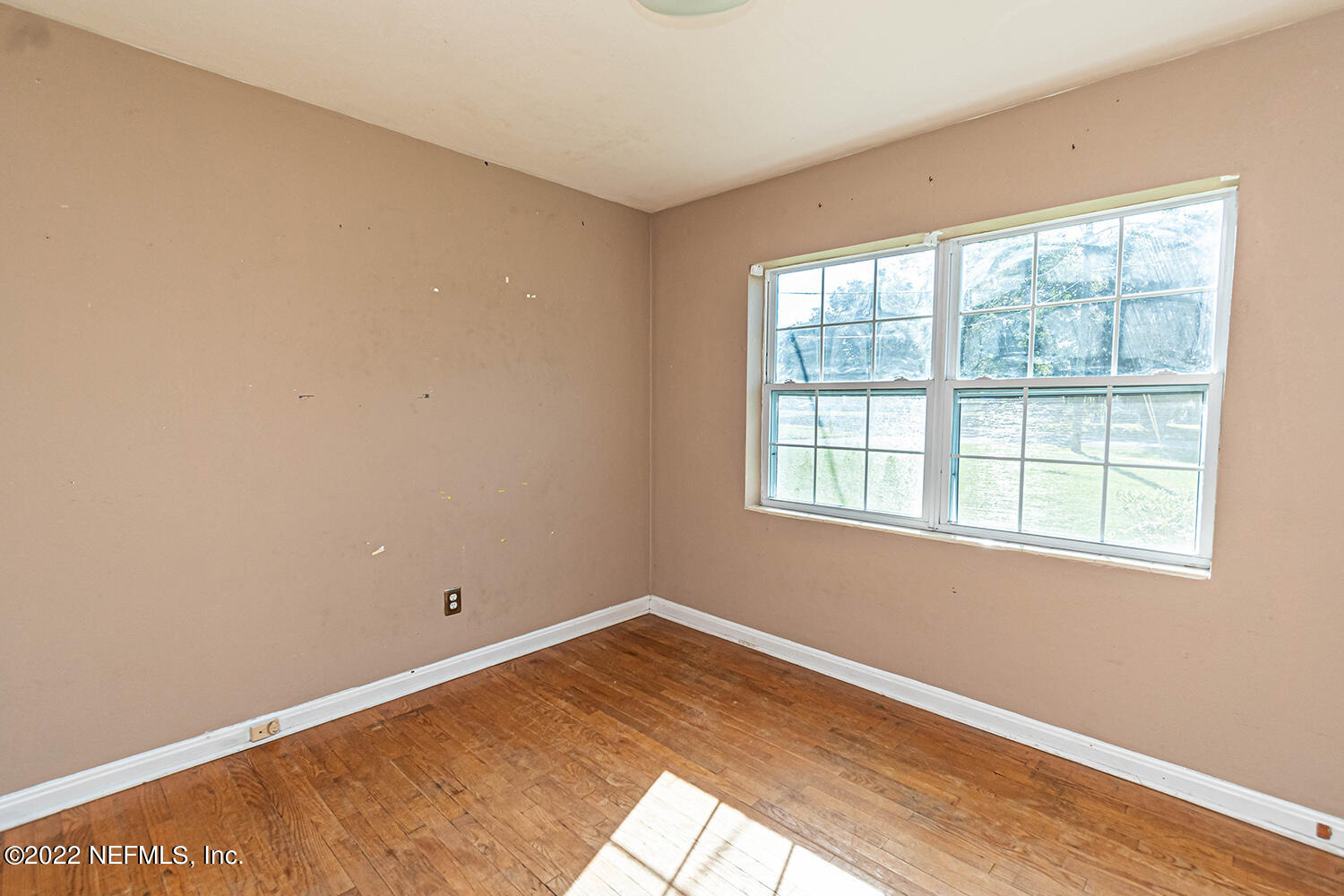 2445 Community Road Jacksonville, FL 32207 - Photo 24 of 42 an empty room with wooden floor and windows