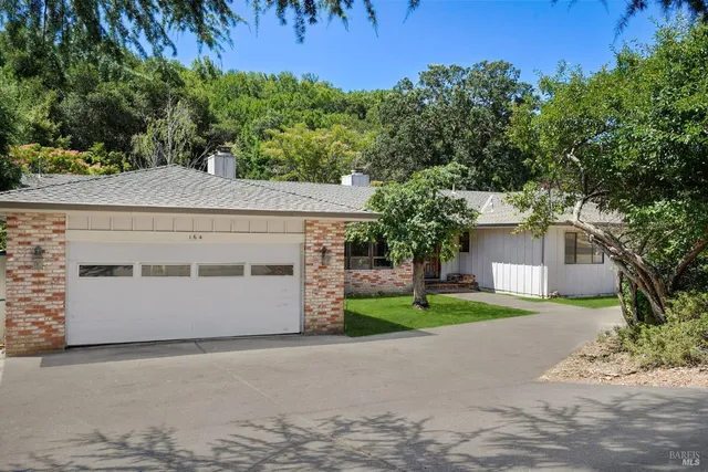 a view of a white house with a yard and garage