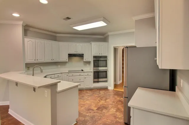 a kitchen with a refrigerator sink and cabinets