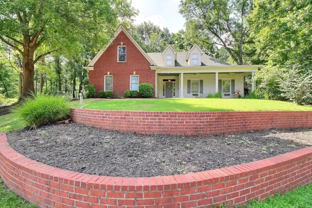 a front view of a house with a yard and trees