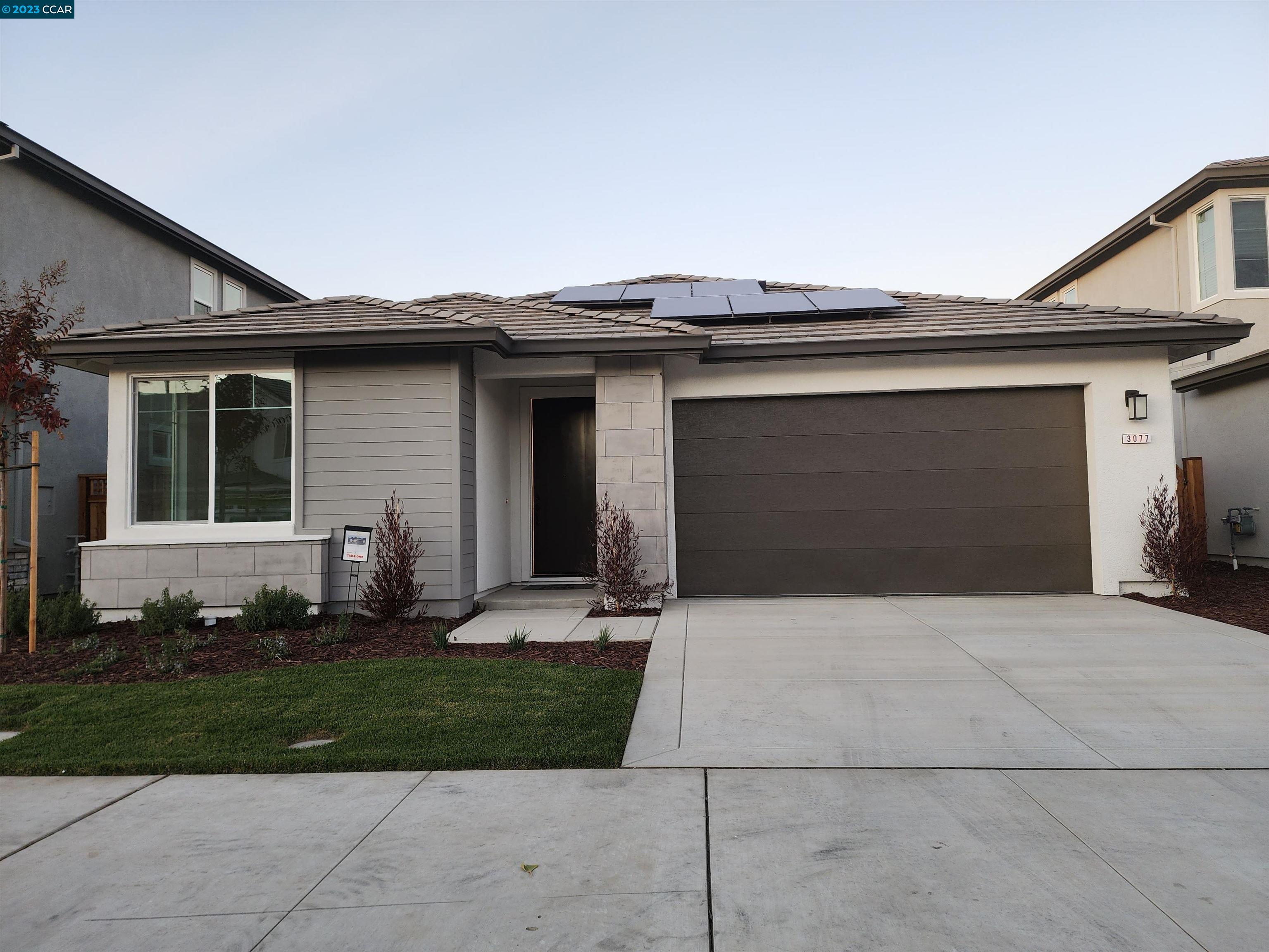a front view of a house with a garden and yard
