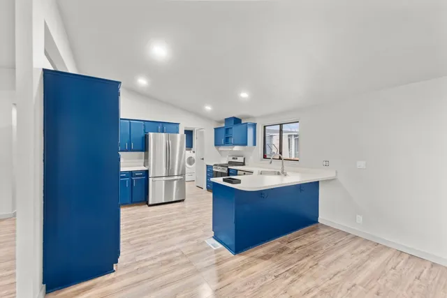 a kitchen with stainless steel appliances granite countertop a sink stove and refrigerator