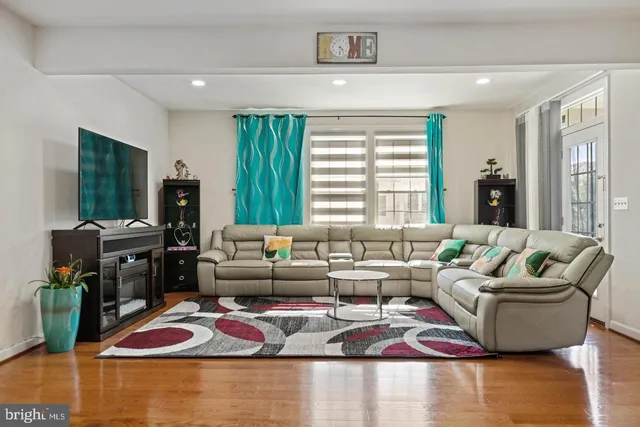 a living room with furniture flat screen tv and a large window