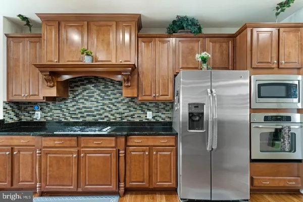 a kitchen with stainless steel appliances granite countertop a refrigerator and a stove