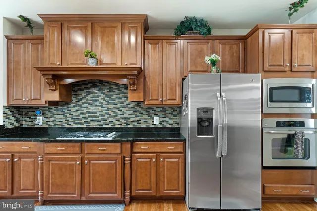 a kitchen with stainless steel appliances granite countertop a refrigerator and a stove