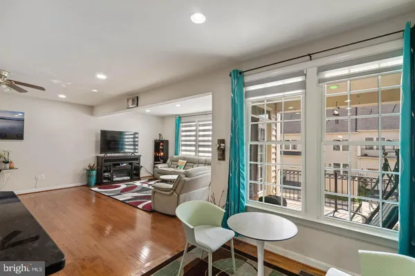 a living room with furniture a flat screen tv and a large window