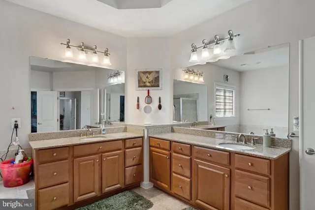 a spacious bathroom with a granite countertop double vanity sink and a mirror
