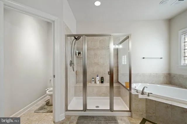 a bathroom with a glass shower door and a bathtub