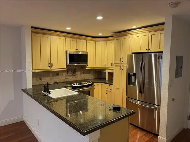 a kitchen with a refrigerator a microwave a sink and a stove