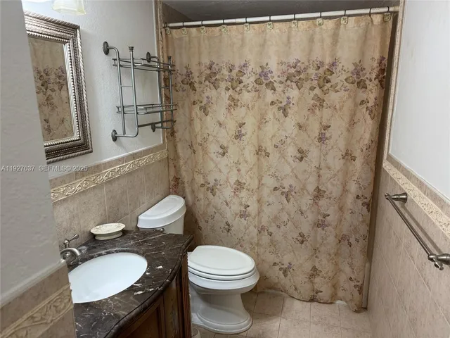 a bathroom with a toilet a sink and a shower