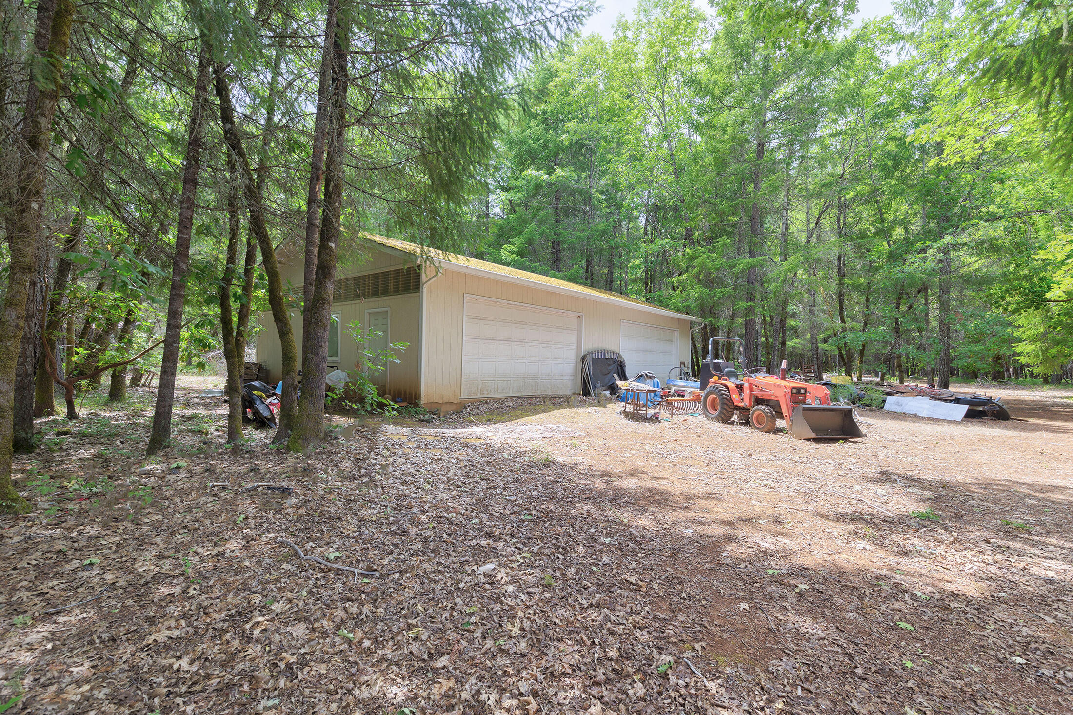 7060 Rockydale Road Cave Junction, OR 97523 - Photo 23 of 33 a view of a house with a backyard and tree
