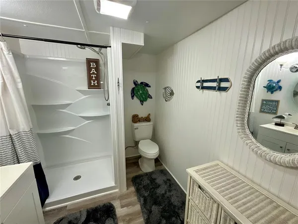 a bathroom with a granite countertop sink a toilet and shower