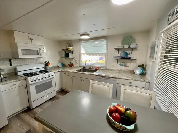 a kitchen with a sink a stove and cabinets