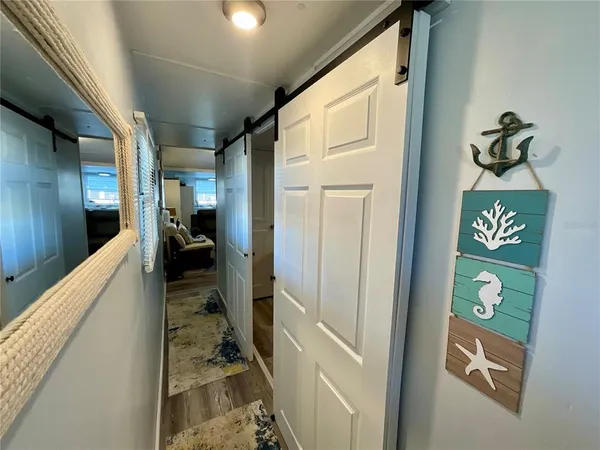 a view of a hallway with a dining table and chairs