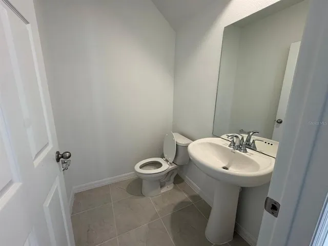 a bathroom with a sink a toilet and mirror