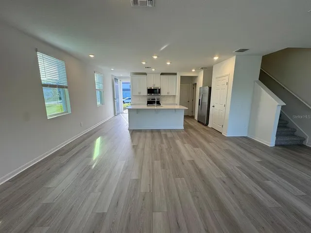 a view of a kitchen with wooden floor and a window