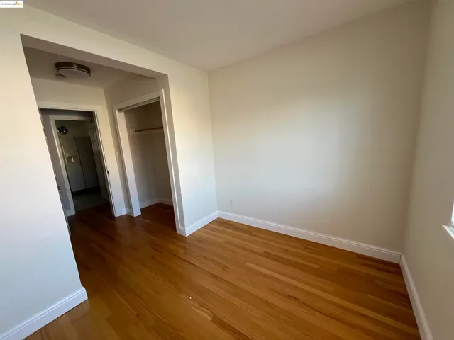 an empty room with wooden floor and closet