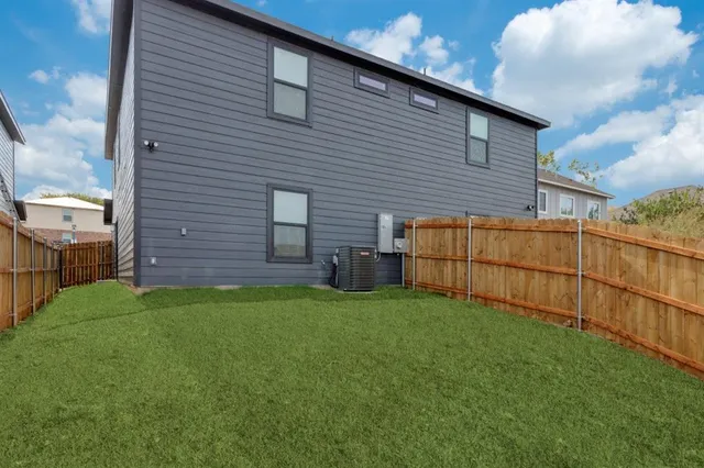 a view of backyard of house with wooden fence