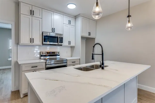 a kitchen with a appliances a sink and cabinets
