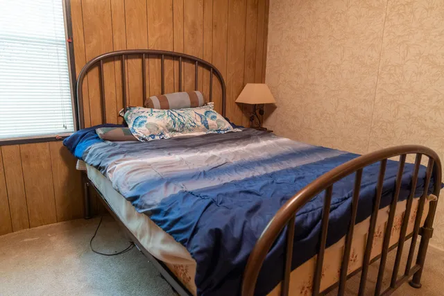 a bed sitting in a bedroom next to a window