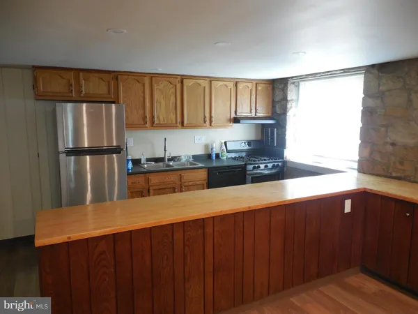 a kitchen with a refrigerator a stove and wooden cabinets