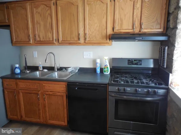 a kitchen with granite countertop wood cabinets and stainless steel appliances