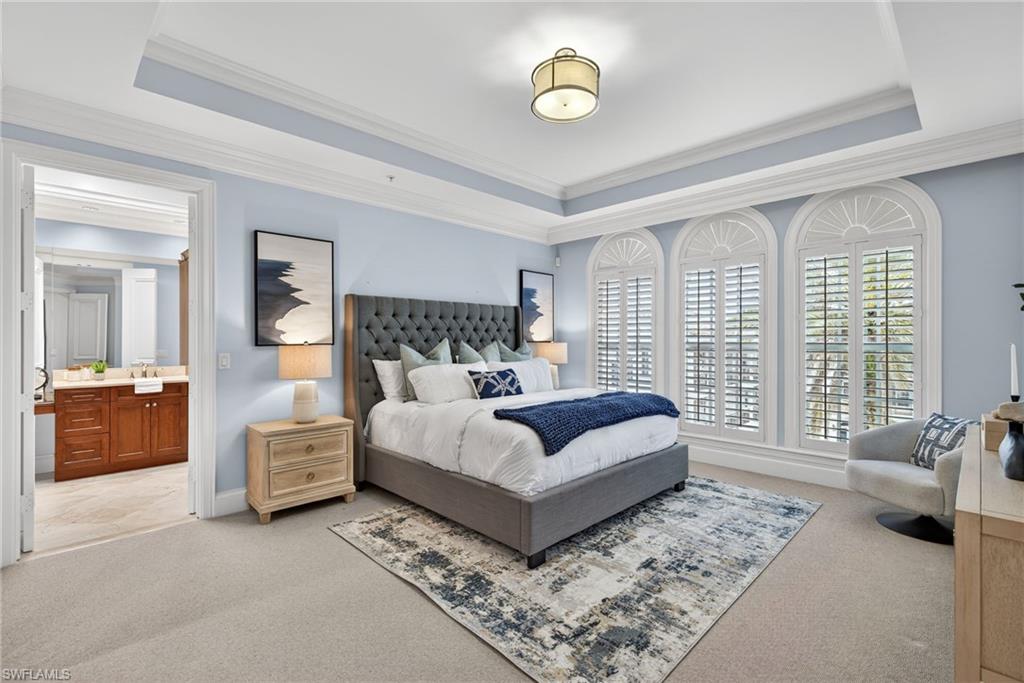 625 5th Avenue South, Unit PH302 Naples, FL 34102 - Photo 16 of 33 Bedroom with ensuite bathroom, crown molding, light carpet, and a raised ceiling
