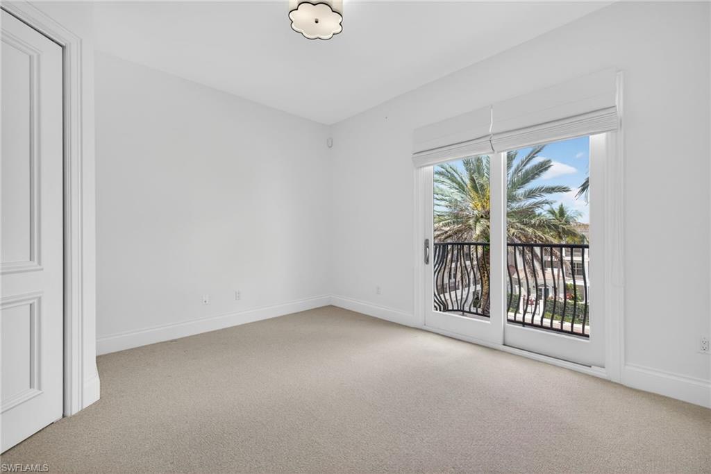 625 5th Avenue South, Unit PH302 Naples, FL 34102 - Photo 21 of 33 Unfurnished room with baseboards and light carpet
