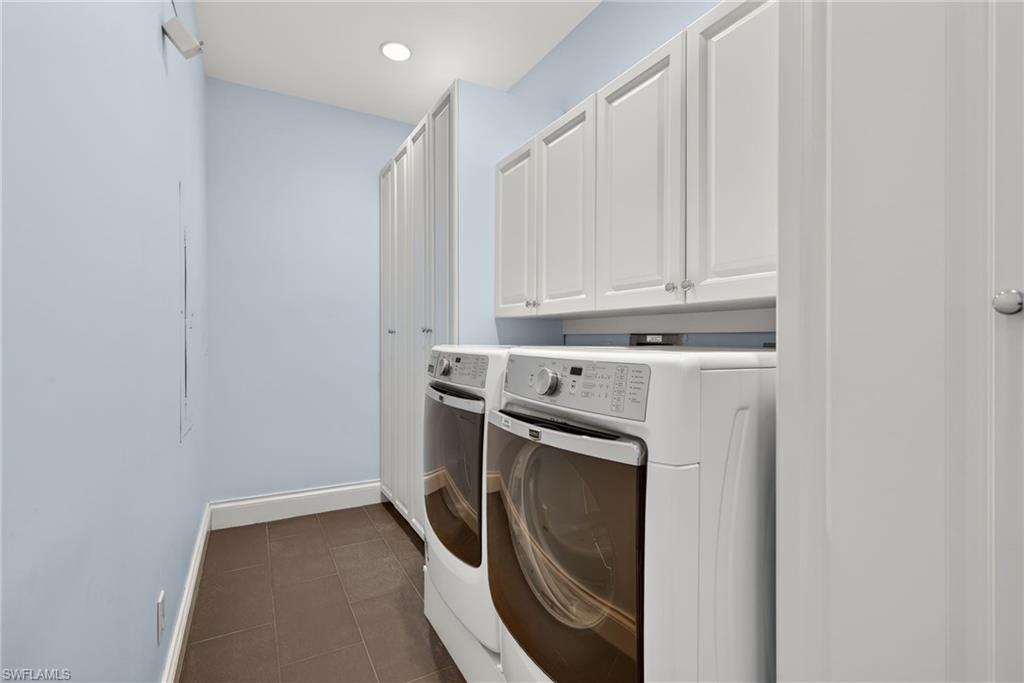 625 5th Avenue South, Unit PH302 Naples, FL 34102 - Photo 24 of 33 Laundry area with cabinet space, dark tile patterned flooring, washing machine and dryer, and recessed lighting
