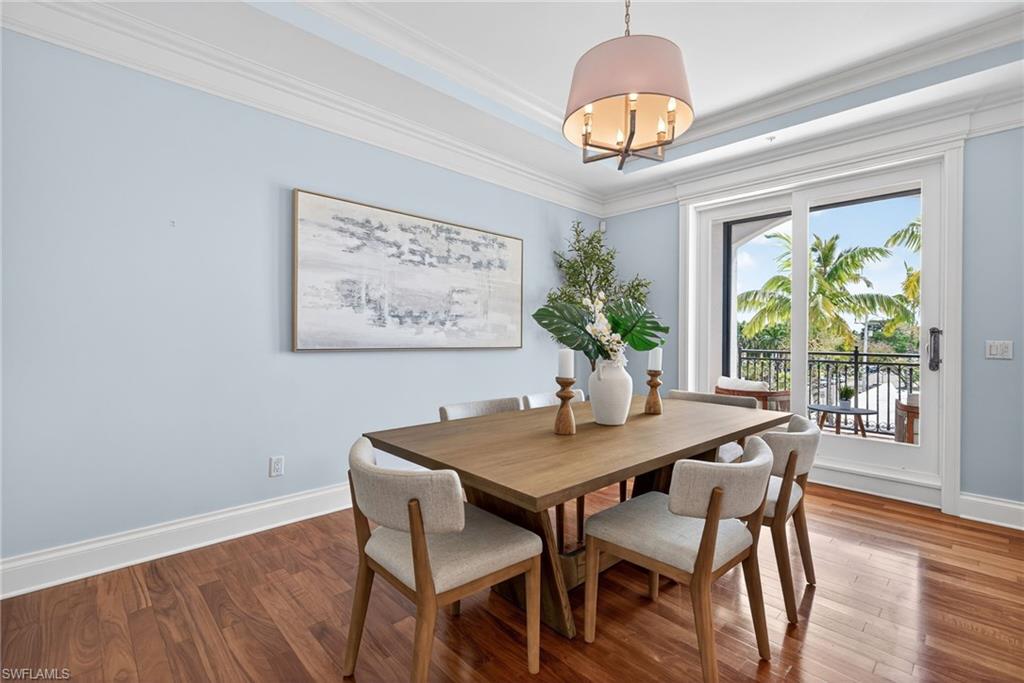 625 5th Avenue South, Unit PH302 Naples, FL 34102 - Photo 6 of 33 Dining room with wood finished floors, ornamental molding, hanging lights, and a raised ceiling