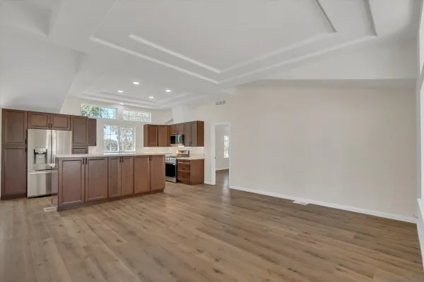 a large white kitchen with a wooden floors and a fireplace