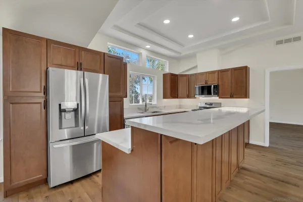 a kitchen with kitchen island a sink stove and refrigerator