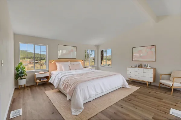 a bedroom with a bed and wooden floor