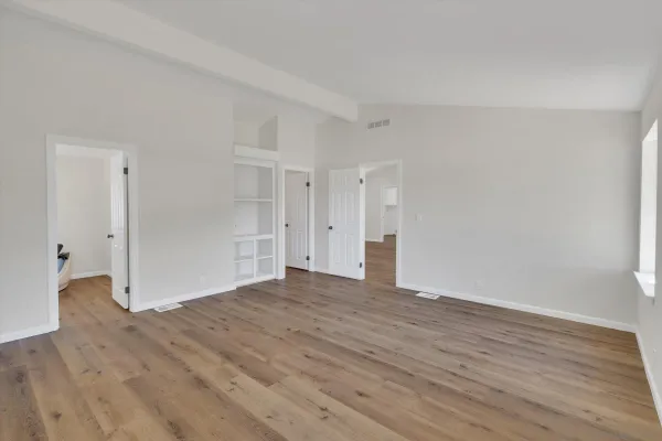 a view of empty room with wooden floor