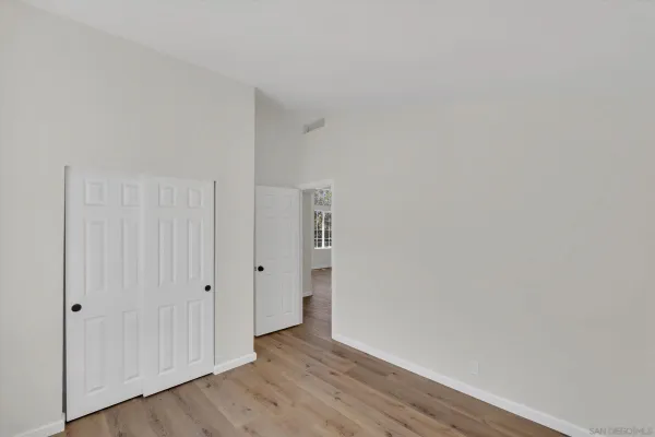 a view of an empty room with wooden floor