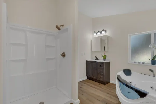 a bathroom with a sink a toilet a mirror and shower