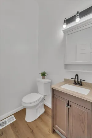 a bathroom with a granite countertop toilet sink and mirror