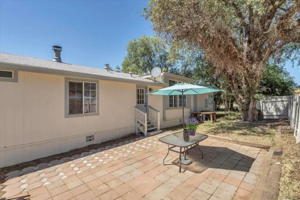 a view of a backyard with table and chairs under an umbrella