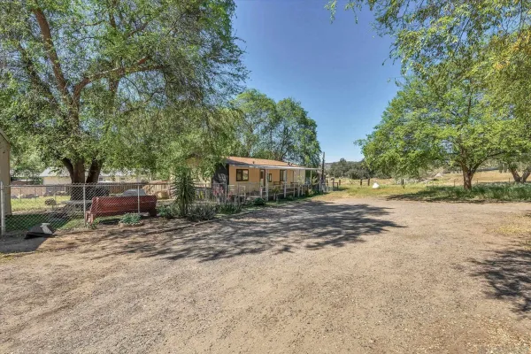 a view of a house with a yard and tree