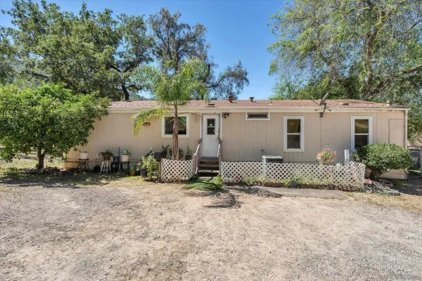 a view of a house with backyard and trees