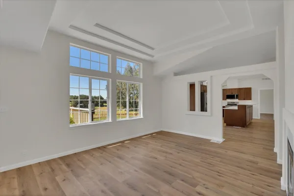 a view of a big room with wooden floor and windows