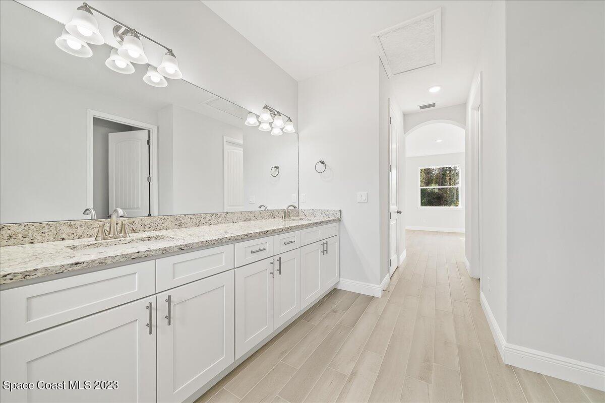 560 Topeka Road Southwest Palm Bay, FL 32908 - Photo 10 of 26 a spacious bathroom with a granite countertop double vanity sink a mirror and a shower