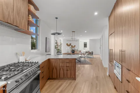 a kitchen with stainless steel appliances granite countertop a stove and a wooden floors