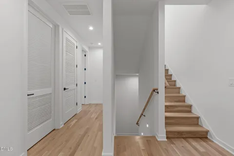 a view of a hallway with wooden floor and entryway