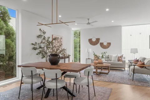 a dining room with furniture and a potted plant